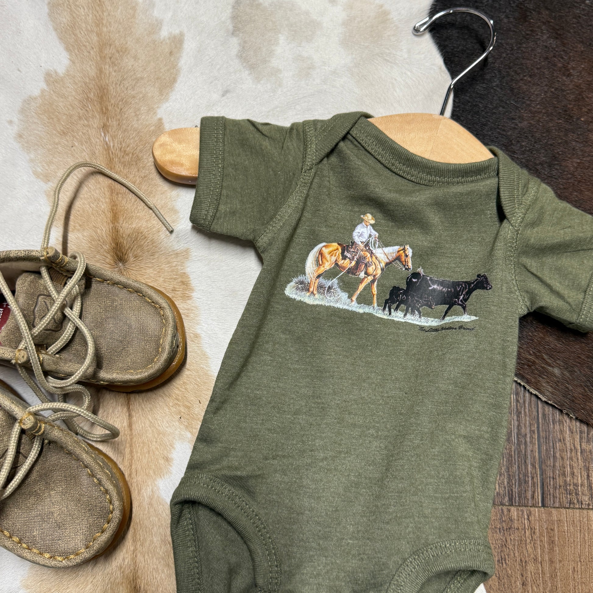 Green onesie with cowboy and cattle