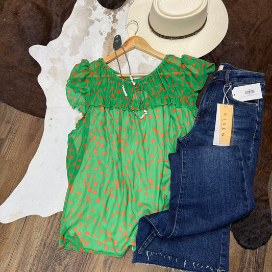 Green chiffon top with orange dots.