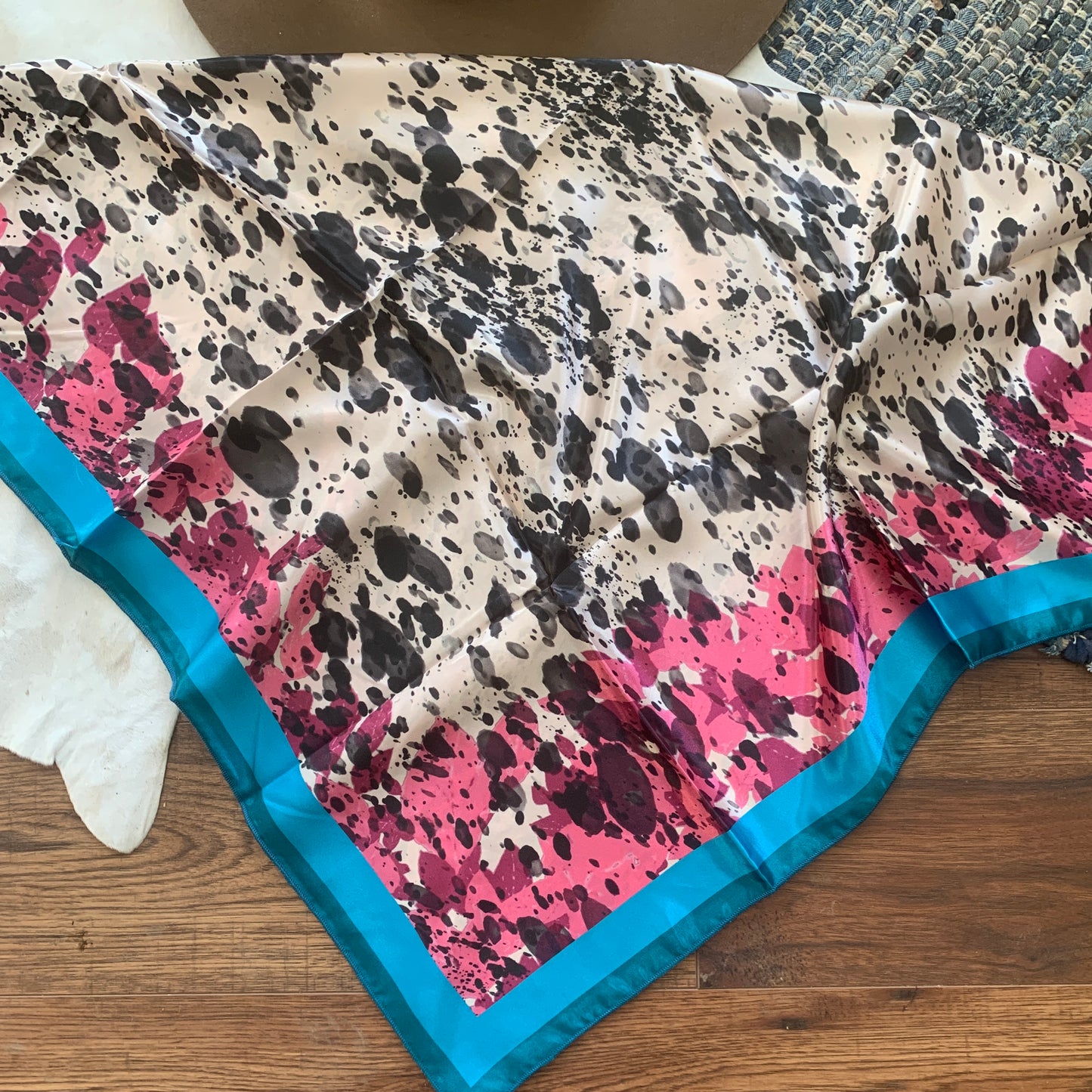 black and white cowprint with a splotched pink and blue border.