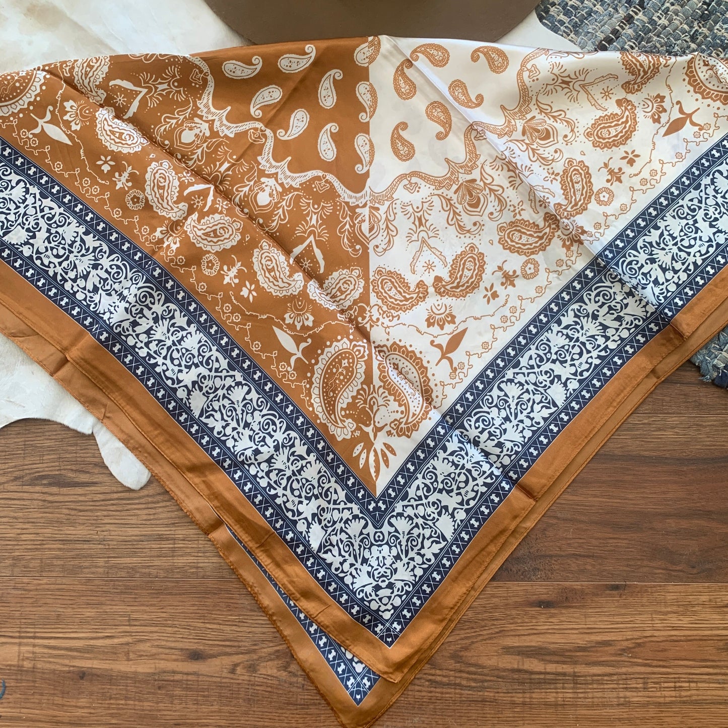 Split background of white and copper with contrasting paisleys and a blue border.