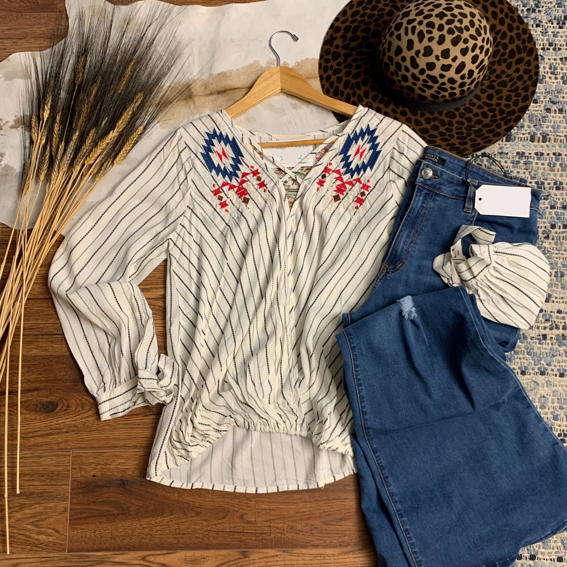 Front view, white and black pinstripe, V-neck with embroidery on front panels.