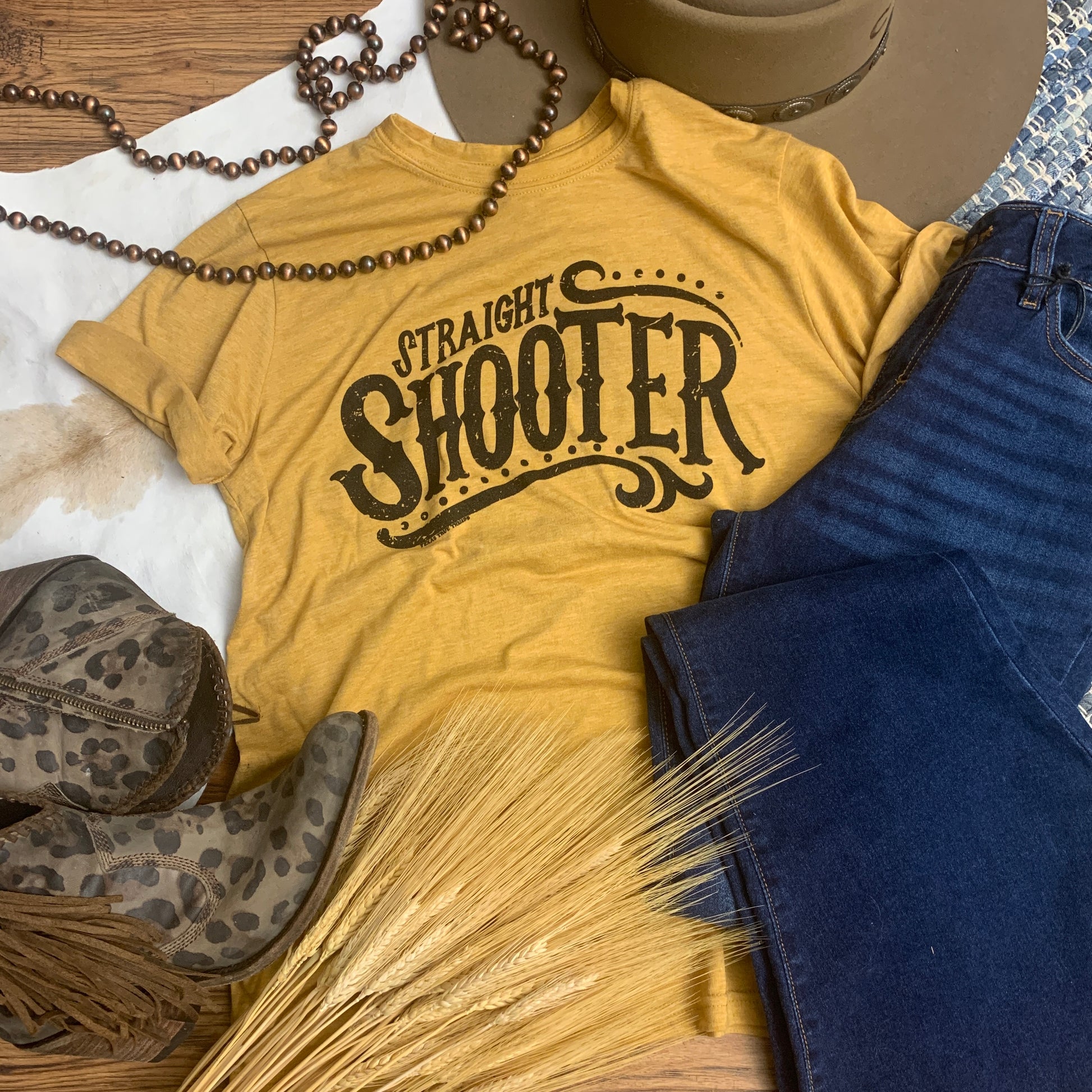 mustard yellow tri blend graphic tee with black lettering that says. "straight shooter"