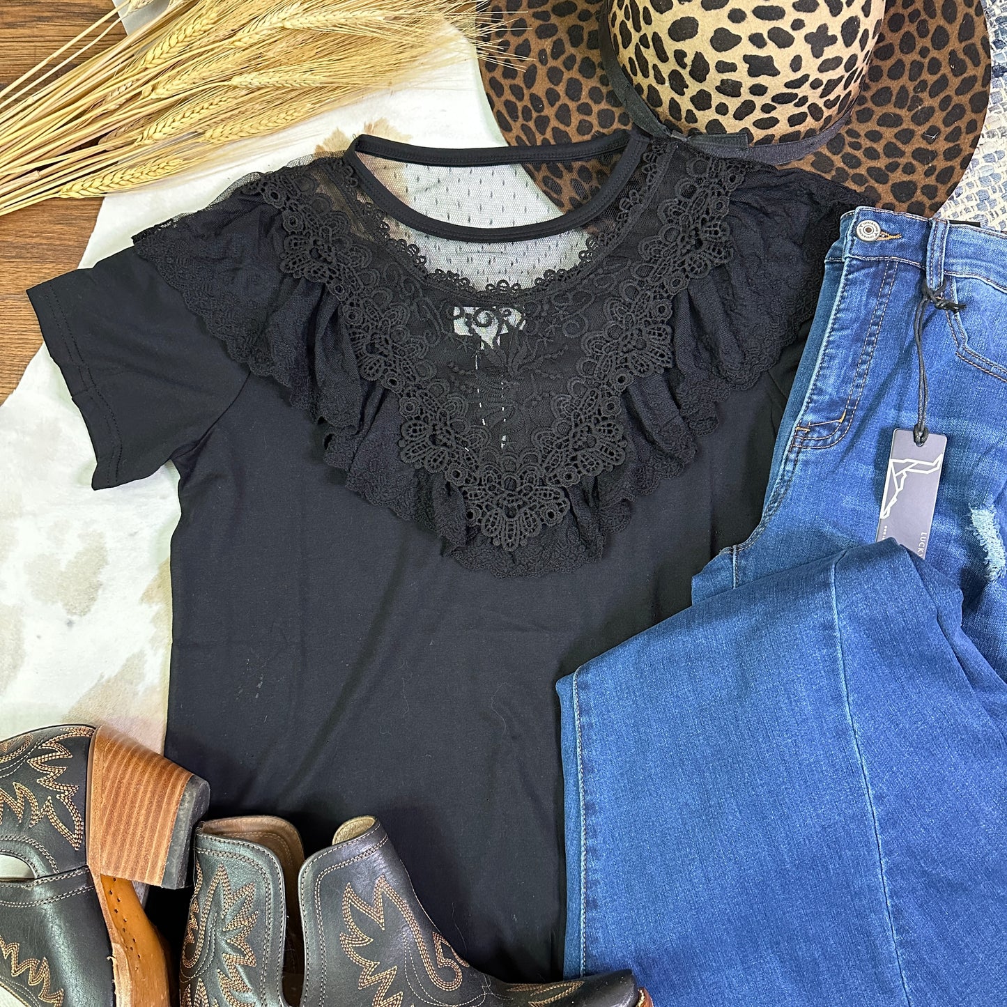 Black knit shirt with ruffles and lace along the v-neckline.