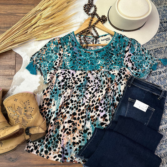 Animal print top with teal embroidery on yoke.