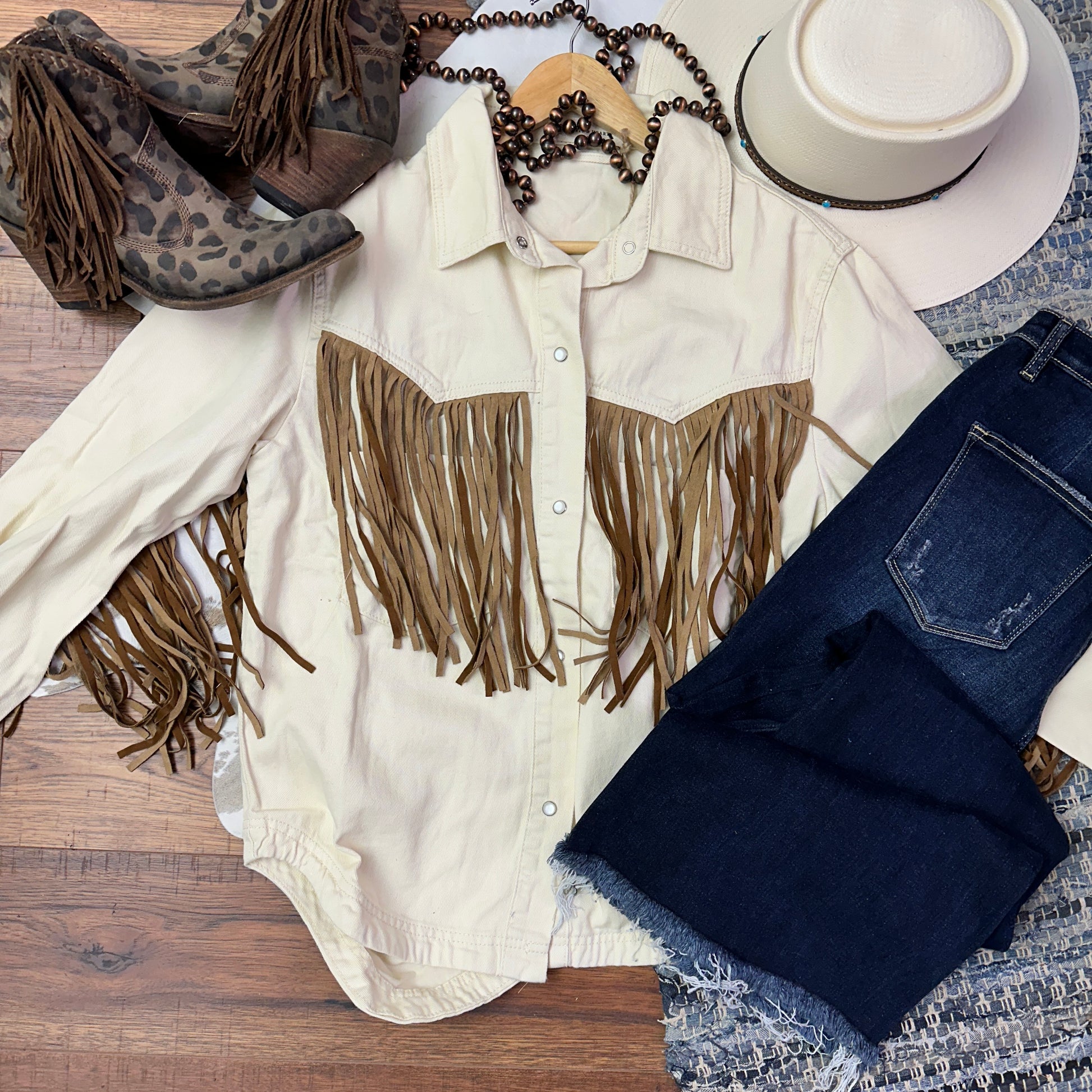 Ivory jacket with brown fringe.