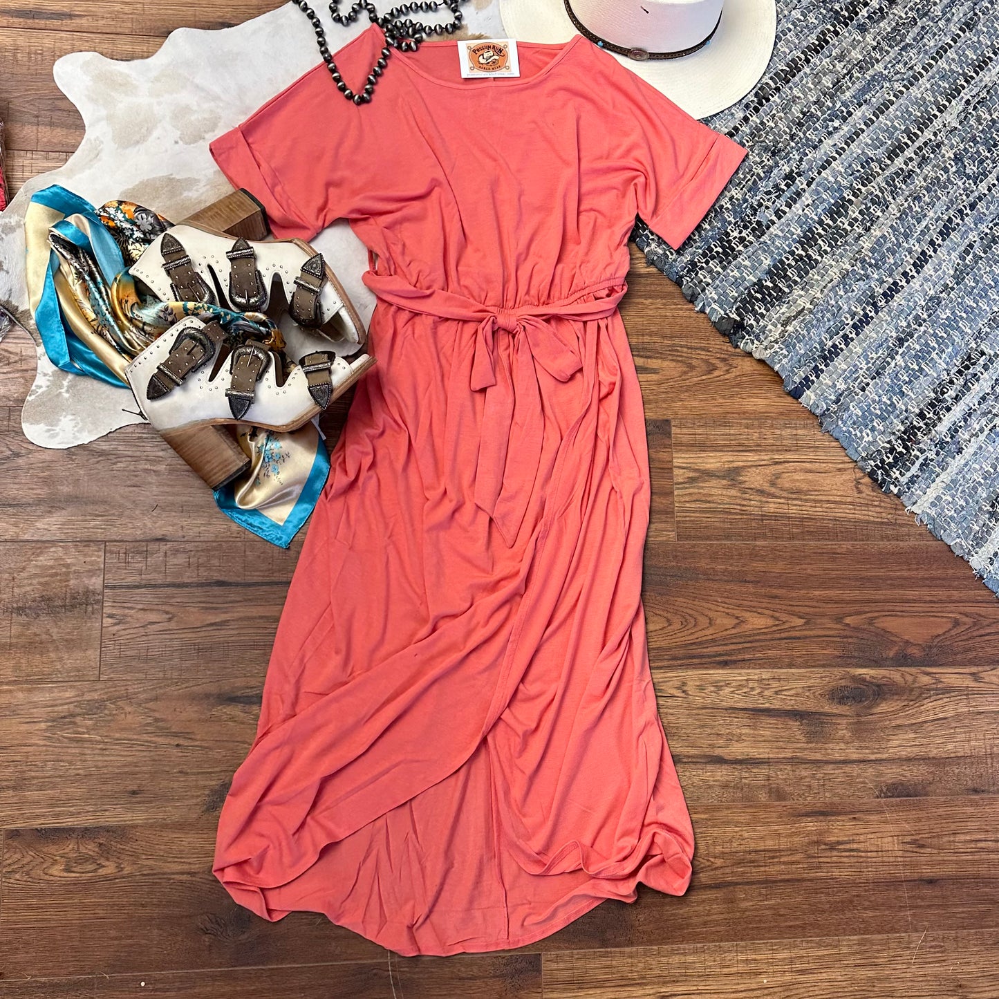 short sleeved coral pink dress with belted waist and tulip hemline.