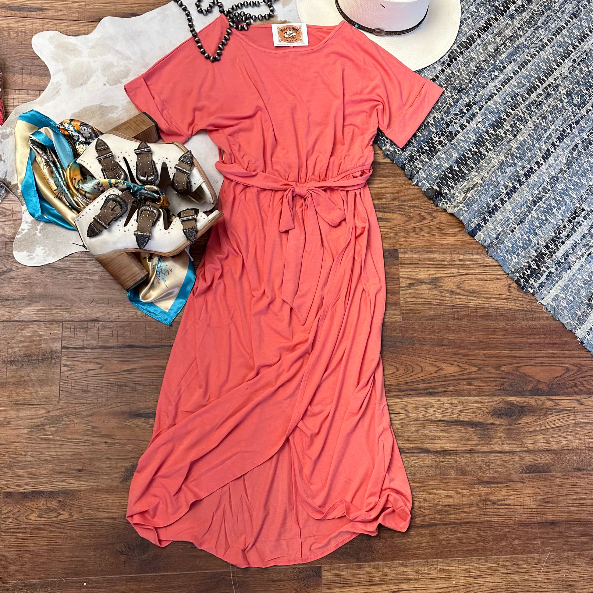 short sleeved coral pink dress with belted waist and tulip hemline.