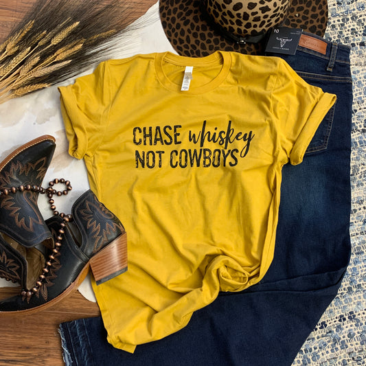 mustard tee that says Chase whiskey not cowboys