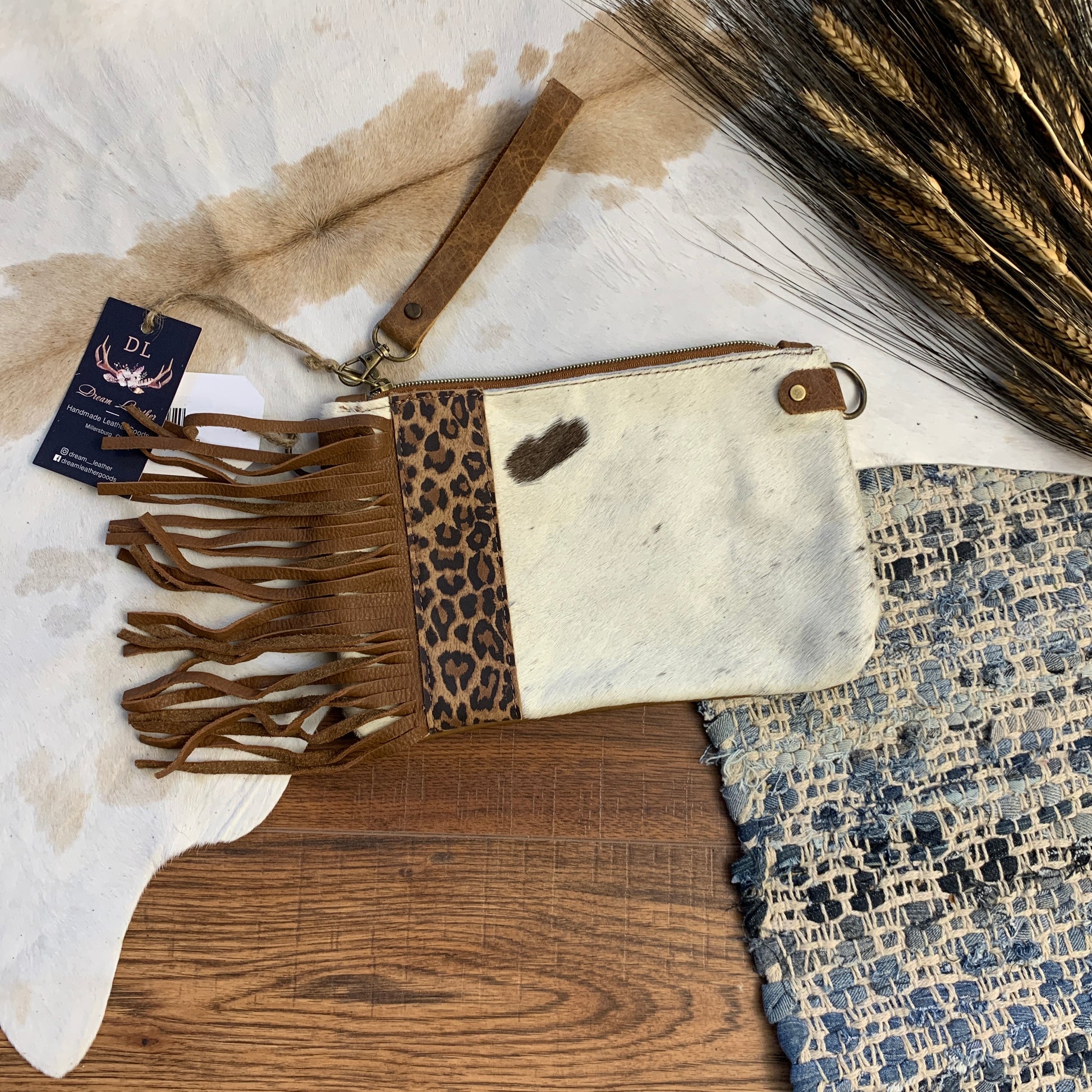 White brown envelope bag with vertical leopard patch and side fringe.