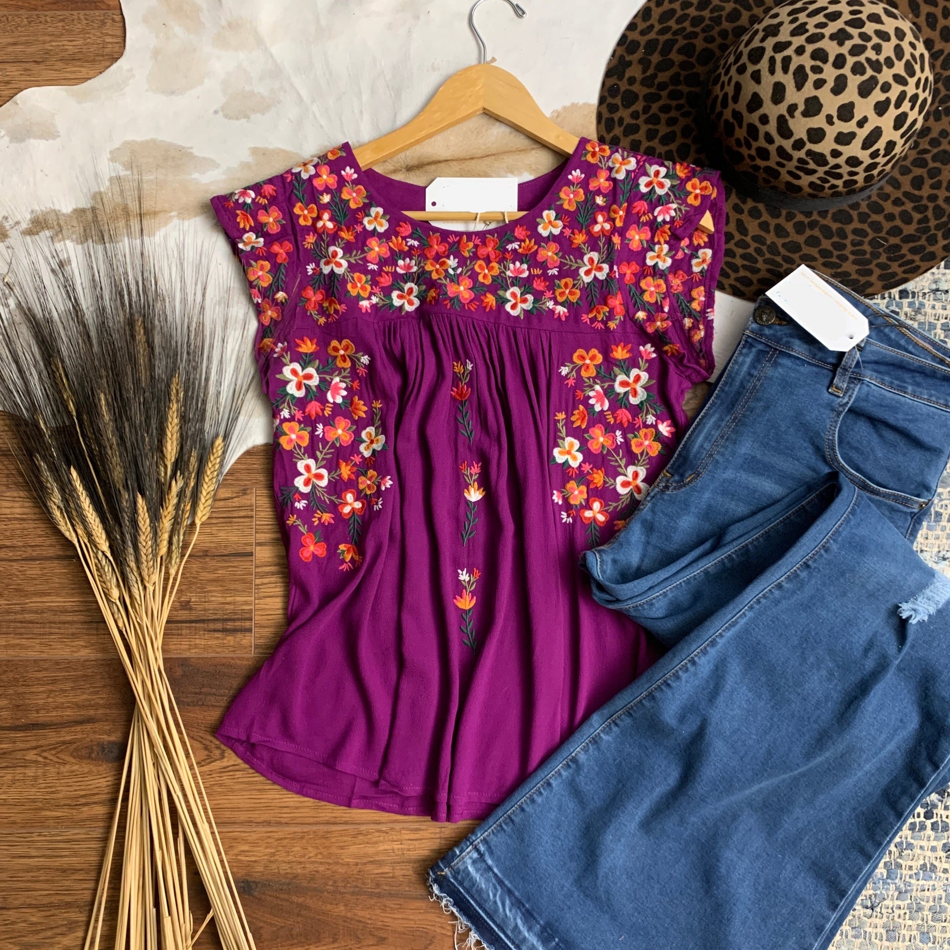 Vibrant purple top with multi colored embroidered flowers on the yoke.